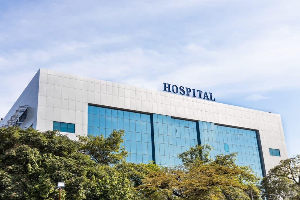 Modern building facade with Hospital word signage against blue sky.