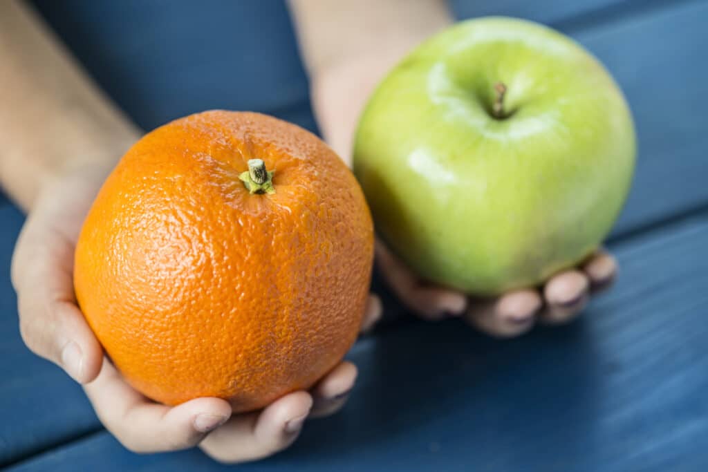 An apple and orange side by side to show comparison.