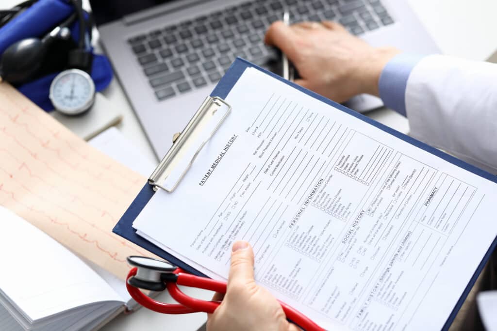 A doctor filling out a patient medical record.